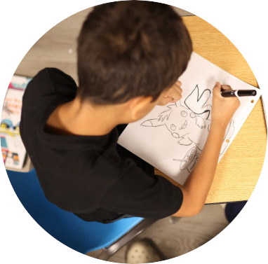 boy drawing in a notebook at Koala ABA the best aba center in Miami